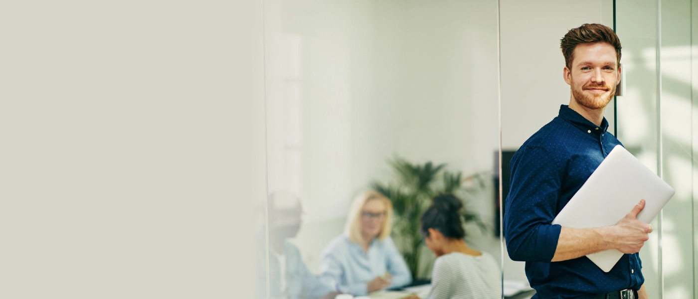 Manlig deltagare i Experis Academy med laptop under armen