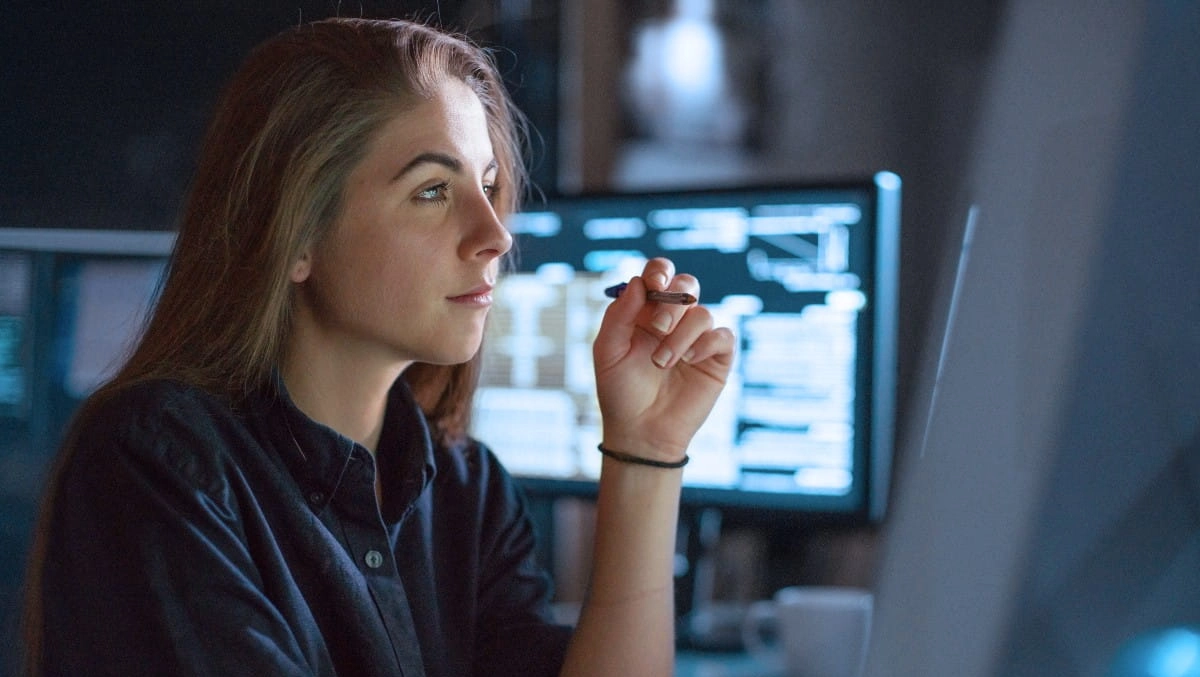 Ung kvinna som deltar i Expers talangprogram tittar fokuserat på sin skärm