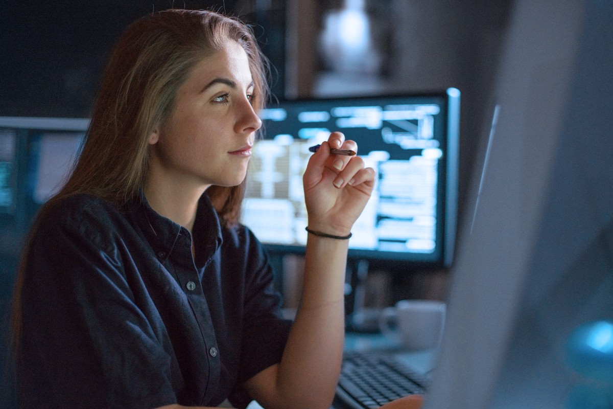 Kvinnlig nätverkstekniker funderar framför skärmen